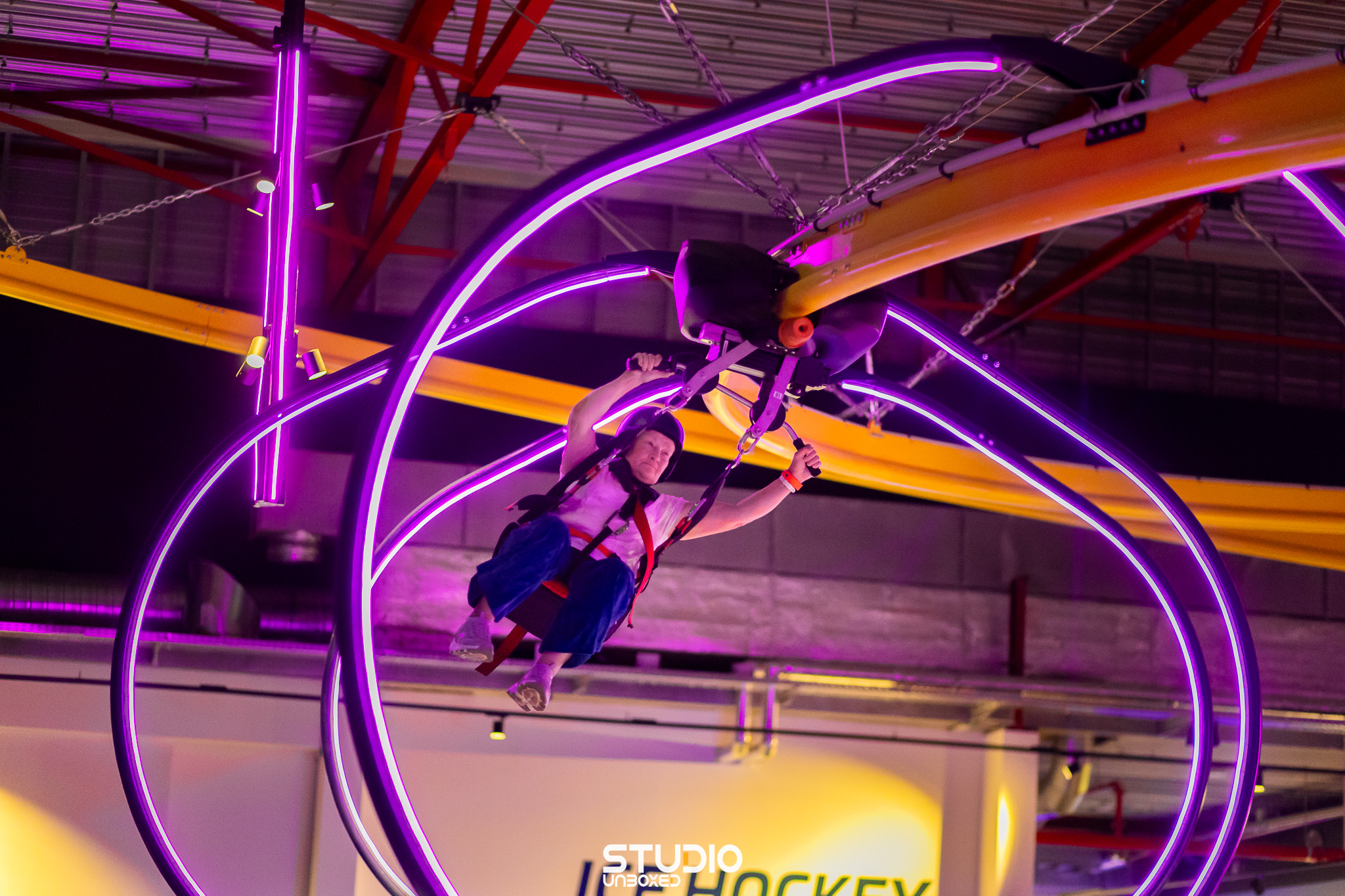 Deelnemers spelen neonverlicht hockey in de sporthal