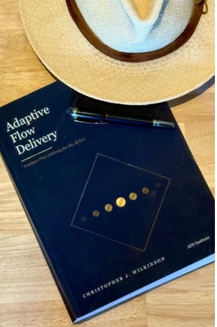 Het boek Adaptive Flow Delivery van Christopher J. Wilkinson, met hoed en pen