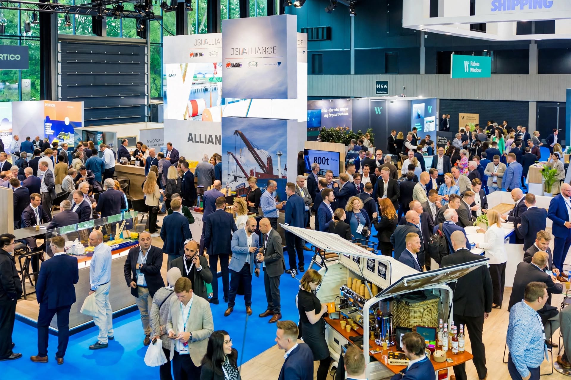 Volle beursvloer met bezoekers rond de mediazone van de beurs